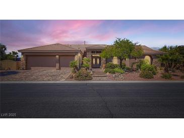 Charming single-story home boasts a well-manicured yard, stone accents, and a three-car garage at 8325 Villa De Medici St, Las Vegas, NV 89131