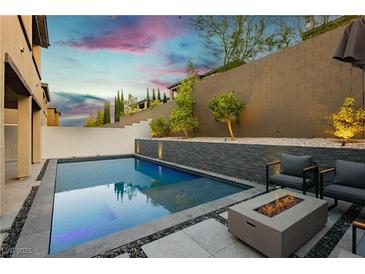 Inviting pool area with a modern fire pit and elegant landscaping, perfect for outdoor relaxation and entertaining at 881 Cherry Glen Pl, Las Vegas, NV 89138