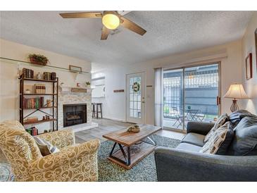 Inviting living room featuring a ceiling fan, fireplace, and sliding glass door to the patio at 227 N Lamb Blvd # B, Las Vegas, NV 89110