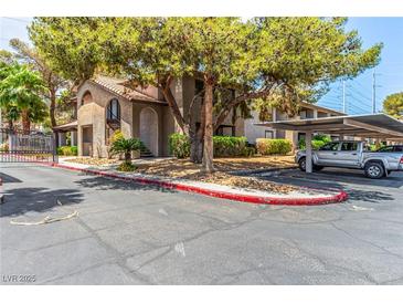 Condo complex with covered parking, mature trees, and well maintained landscaping, including gate, curbs and trees at 2606 Durango Dr # 181, Las Vegas, NV 89117