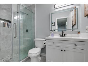 Modern bathroom features a glass shower, sleek vanity with illuminated mirror at 709 Jonathan Glen Way, Las Vegas, NV 89145