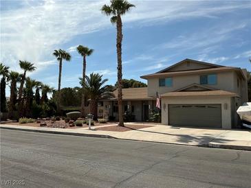 Charming two-story home featuring a well-manicured front yard and an attached two-car garage at 893 Fairway Dr, Boulder City, NV 89005