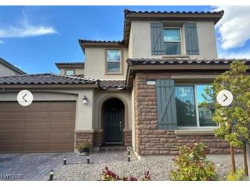 Charming two-story home with a stone facade and a well-manicured front yard at 10142 Skye Saddle Ave, Las Vegas, NV 89166