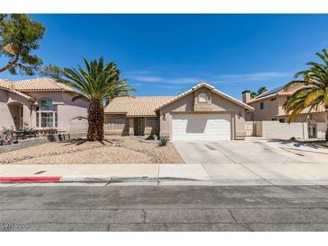 Charming single-story home featuring a two-car garage, desert landscaping and mature palm trees at 1824 Dawn Ridge Ave, Henderson, NV 89074