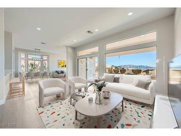 Bright living room with large windows and modern decor, seamlessly flowing into the dining area at 2904 Bow Bridge Dr, Las Vegas, NV 89134