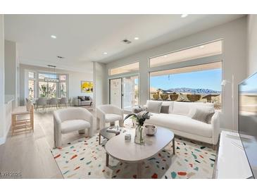 Bright, open-concept living room featuring a modern design, large windows, and mountain views at 2904 Bow Bridge Dr, Las Vegas, NV 89134