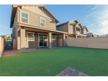 Spacious backyard features an artificial lawn and covered patio, perfect for entertaining at 361 Andy Wheeler Dr, Henderson, NV 89011