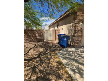 Side yard featuring rock landscaping, privacy wall, and gate access to the house at 3910 Internet Ave, North Las Vegas, NV 89031