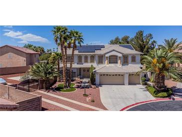 Expansive two-story home featuring a three-car garage, desert landscaping and solar panels on the roof at 7141 Groveton Ct, Las Vegas, NV 89131