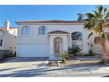 Charming two-story home featuring a desert-landscaped front yard and a white stucco exterior with red tile roof at 8717 Harvest Valley Ave, Las Vegas, NV 89129