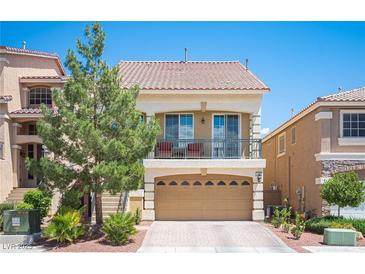 Charming two-story home with a balcony, two-car garage, and desert landscaping under a clear blue sky at 9450 Niagara Landing St, Las Vegas, NV 89139