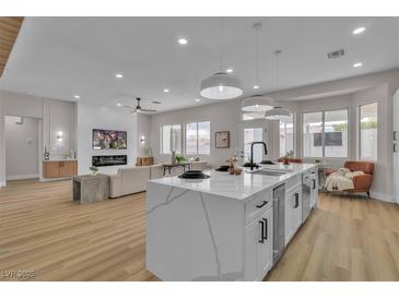 Bright, open-concept living room with modern finishes and a large kitchen island for entertaining at 10886 Porto Foxi St, Las Vegas, NV 89141