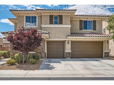 Charming two-story home featuring a two-car garage, stone accents, and a beautifully landscaped front yard at 1113 Via Della Costrella, Henderson, NV 89011