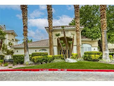Charming building entrance framed by palm trees and lush landscaping at 1420 Red Crest Ln # 202, Las Vegas, NV 89144