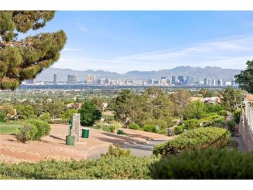 Striking city views from this hillside home in Las Vegas with mature trees and a lovely golf course at 2742 Darby Falls Dr, Las Vegas, NV 89134