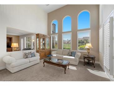 Bright living room featuring high ceilings, large arched windows, and comfortable seating arrangements at 2933 Red Springs Dr, Las Vegas, NV 89135