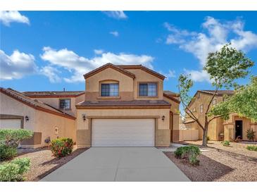 Inviting two-story home featuring a two-car garage and desert landscaping under a beautiful blue sky at 6525 Bismark Hills St, North Las Vegas, NV 89084