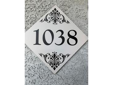 Close up of the house number 1038 on a decorative plaque mounted to a textured wall at 6955 N Durango Dr # 1038, Las Vegas, NV 89149