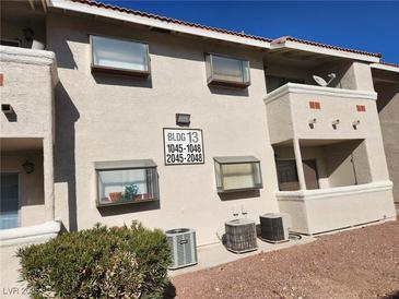 Tan building exterior with visible unit numbers and well-maintained landscaping at 7300 Pirates Cove Rd # 2045, Las Vegas, NV 89145