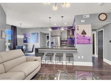 Open-concept living room with modern lighting, sleek furniture, and a stylish kitchen area with bar seating at 9000 S Las Vegas Blvd # 2222, Las Vegas, NV 89123