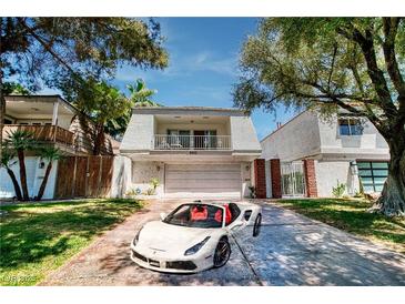 Charming two-story home with a well-manicured lawn and a luxury sports car in the driveway at 940 Vegas Valley Dr, Las Vegas, NV 89109