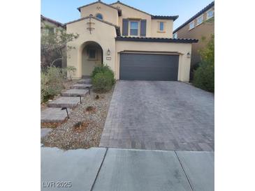 Two-story home with a two-car garage, stone driveway, desert landscaping, and a covered front entry at 11815 Corenzio Ave, Las Vegas, NV 89138