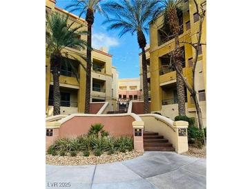 Condominium complex exterior view with palm trees, landscaping, and entrance stairs at 270 E Flamingo Rd # 214, Las Vegas, NV 89169