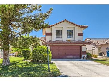 Charming two-story home with a well-manicured lawn and mature trees on a sunny day at 5517 Bowerman Way, Las Vegas, NV 89130