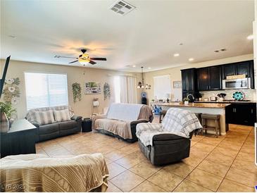Spacious living room featuring tile floors, a ceiling fan, and plenty of natural light at 5634 Bishop Flowers St, Las Vegas, NV 89130