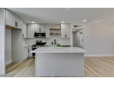 Bright kitchen featuring an island, stainless steel appliances, and sleek gray cabinetry at 6100 Fawn Cir, Las Vegas, NV 89107
