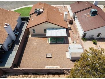 Aerial view of a backyard with gravel landscaping, covered patio, and detached storage shed at 7268 Wichita Ct, Las Vegas, NV 89119