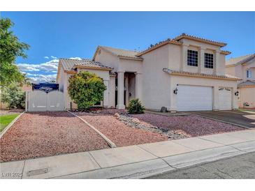 Charming two-story home featuring a three-car garage, rock landscaping, and manicured shrubbery in a suburban setting at 7817 Safari Ln, Las Vegas, NV 89129