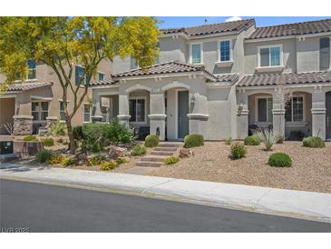 Beautiful townhome featuring a well-manicured lawn and desert landscaping, enhanced by a shade tree at 946 Belton Lake Ave, North Las Vegas, NV 89086