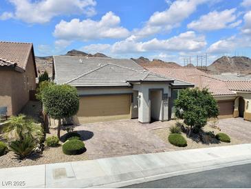Charming single-story home featuring a well-manicured front yard, stone driveway and a two-car garage at 1063 Upper Springs St, Henderson, NV 89002