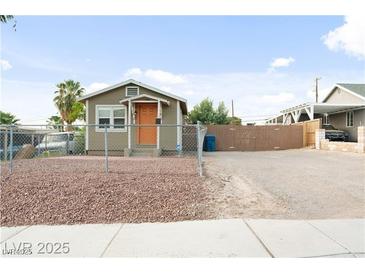 Charming single story home featuring a large gravel driveway and orange front door at 1718 Marlin Ave, Las Vegas, NV 89101