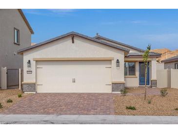 Charming single-story home with a two-car garage, brick driveway, and desert landscaping at 2611 Freya Valley St, Las Vegas, NV 89156