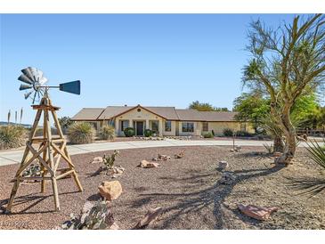 Charming single-story home with desert landscaping and a decorative windmill on a spacious lot at 4075 W Torino Ave, Las Vegas, NV 89139
