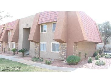 An exterior view showcasing a two-story condo with a tiled roof and stone facade at 4965 Indian River Dr # 101, Las Vegas, NV 89103