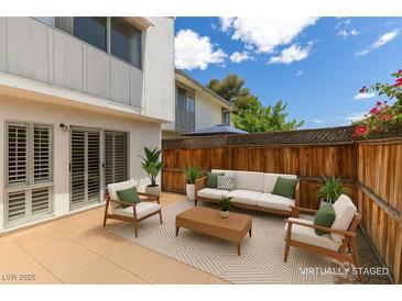 Charming patio with comfortable seating, neutral tones, and privacy fence, perfect for relaxing outdoors at 516 Delfern Ln, Las Vegas, NV 89169