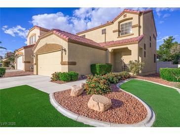 Two-story stucco home with a red tile roof, well-manicured lawn, and a two-car garage at 7916 Nesting Pine Pl, Las Vegas, NV 89143