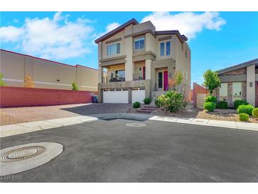 A modern two-story home featuring a stucco facade, balcony, two-car garage, and low-maintenance landscaping at 9045 Knots Estate St, Las Vegas, NV 89139