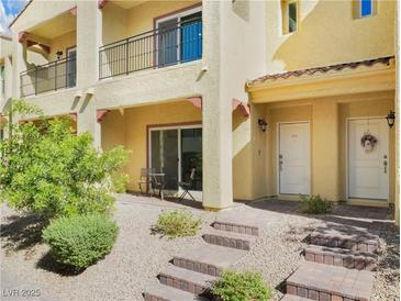 Charming townhome featuring a covered front porch and a well-maintained landscaped front yard at 985 Via Lombardi Ave, Henderson, NV 89011