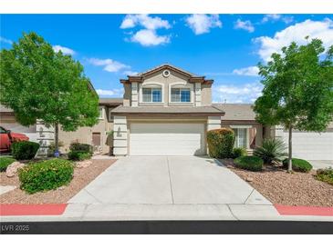 Charming two-story townhouse featuring a two-car garage, well-maintained landscaping and a concrete driveway at 10244 Amber Hue Ln, Las Vegas, NV 89144
