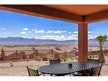 Enjoy mountain views from this covered patio with wrought iron table and chairs for outdoor dining at 1424 Pin Cushion Rdg, Mesquite, NV 89034