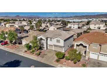 Two-story home featuring a two-car garage, desert landscaping and tile roof at 272 Violet Note St, Henderson, NV 89074