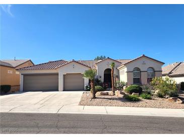 Charming single-story home featuring stucco walls, tile roof, desert landscaping, and a convenient three-car garage at 2809 Winslow Springs Dr, Henderson, NV 89052