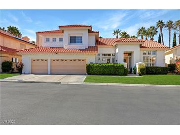 Inviting two-story home boasts a three-car garage, lush landscaping, and a red tile roof at 2909 Sterling Cove Dr, Las Vegas, NV 89128