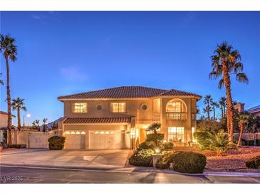 Elegant two-story home with a three-car garage, well-manicured landscaping, and a charming front porch with stone accents at 4471 Borrego Springs Way, Las Vegas, NV 89129