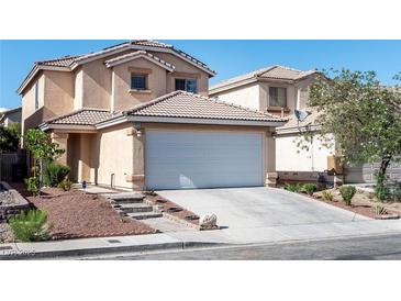 Two-story home featuring an attached two-car garage with a driveway and landscaped front yard at 4846 Lone Grove Dr, Las Vegas, NV 89139