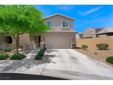 Charming two-story home with desert landscaping, green tree and covered front porch at 5631 Hill Cliff Ct, North Las Vegas, NV 89031